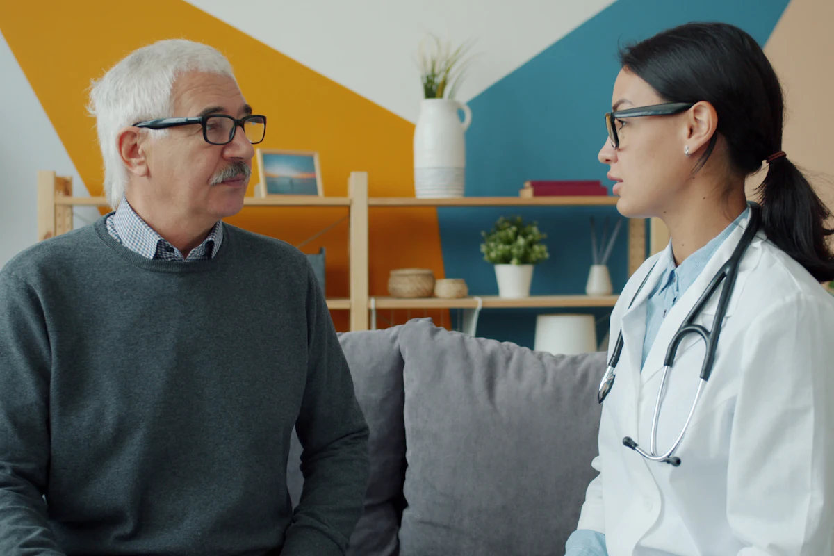 Señor mayor hablando con una doctora durante una consulta