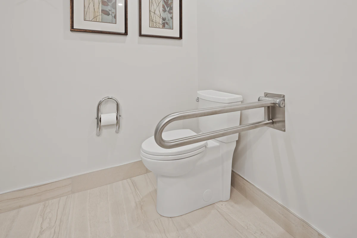 Baño adaptado con barra de apoyo abatible junto al inodoro