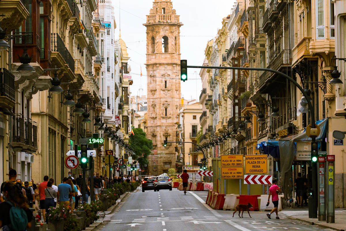Calle del centro histórico de València con un campanario al fondo