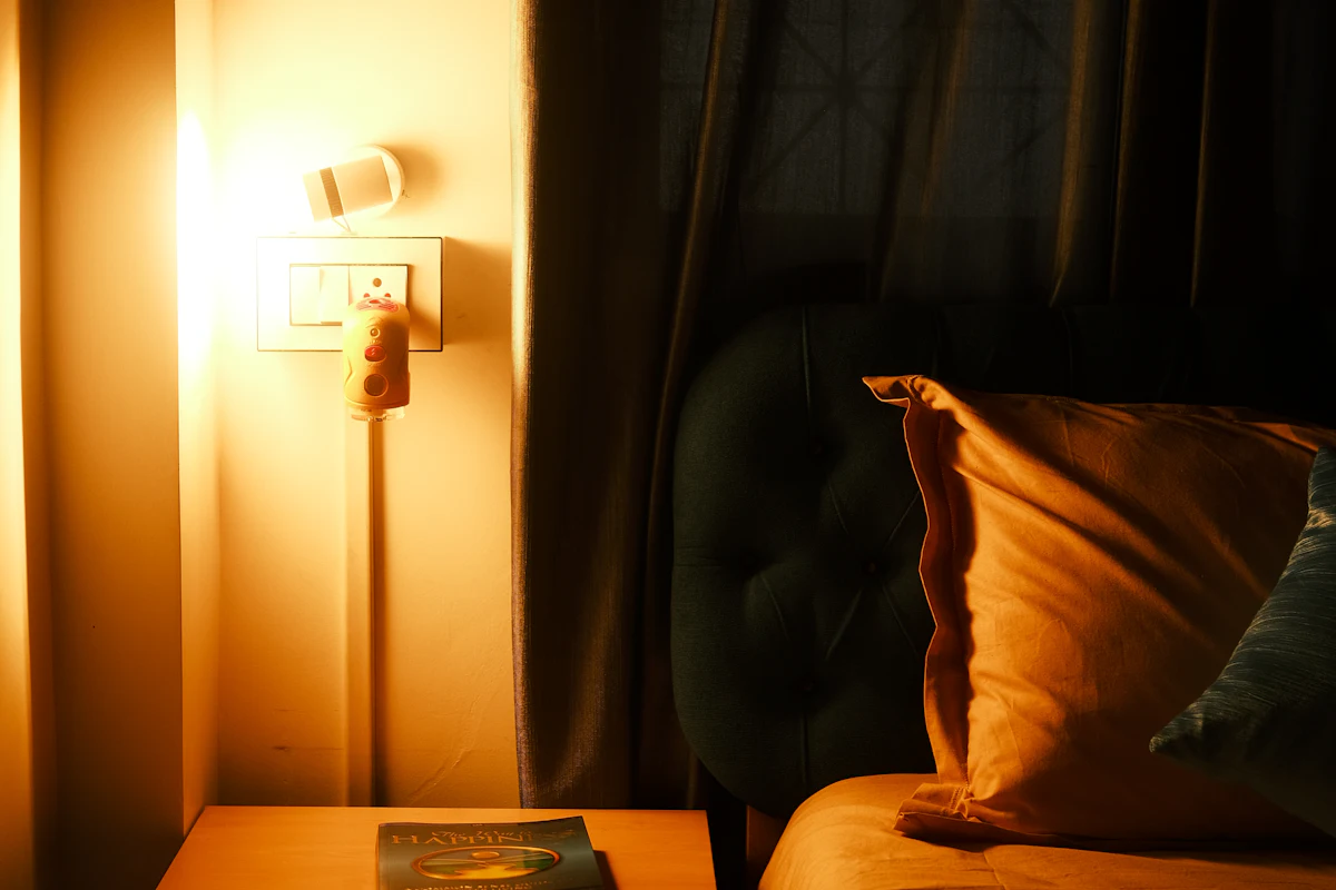 Dormitorio de noche iluminado por una lámpara de luz cálida