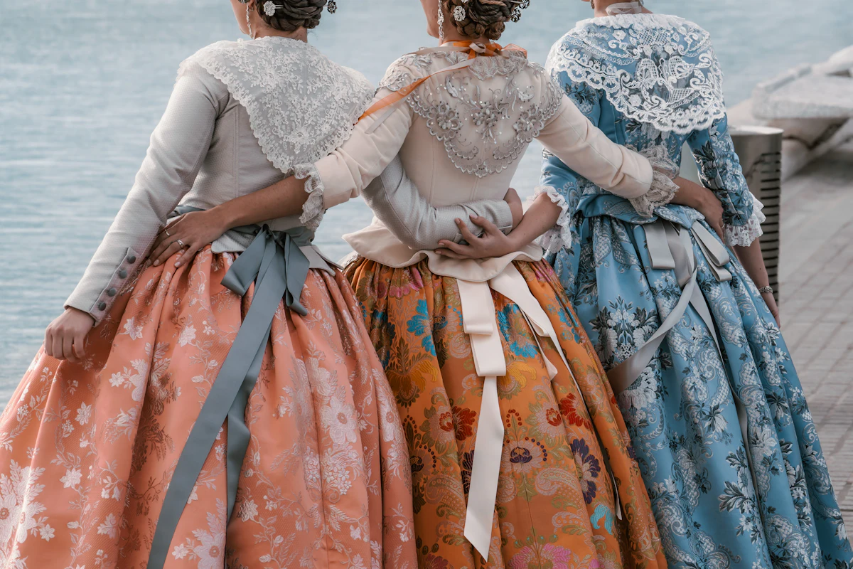 Tres falleras de espaldas con el traje tradicional valenciano