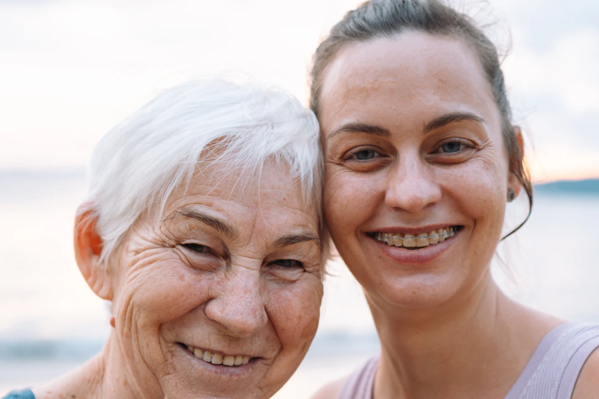 Madre mayor e hija sonriendo juntas